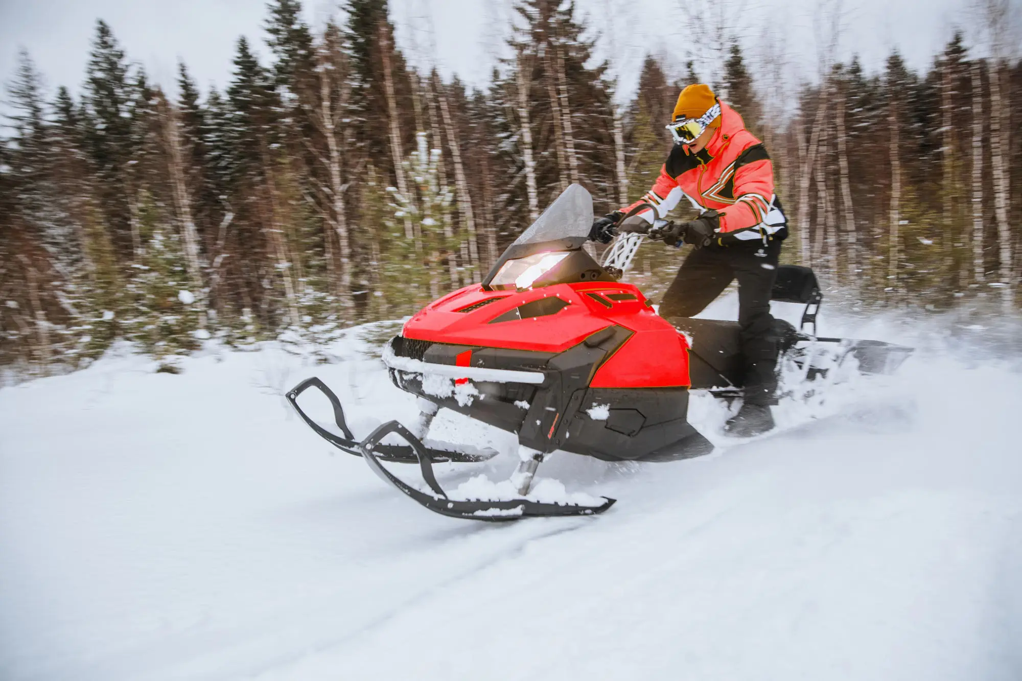 a-man-rides-a-yellow-snowmobile-through-a-winter-f-2021-12-10-19-52-26-utc