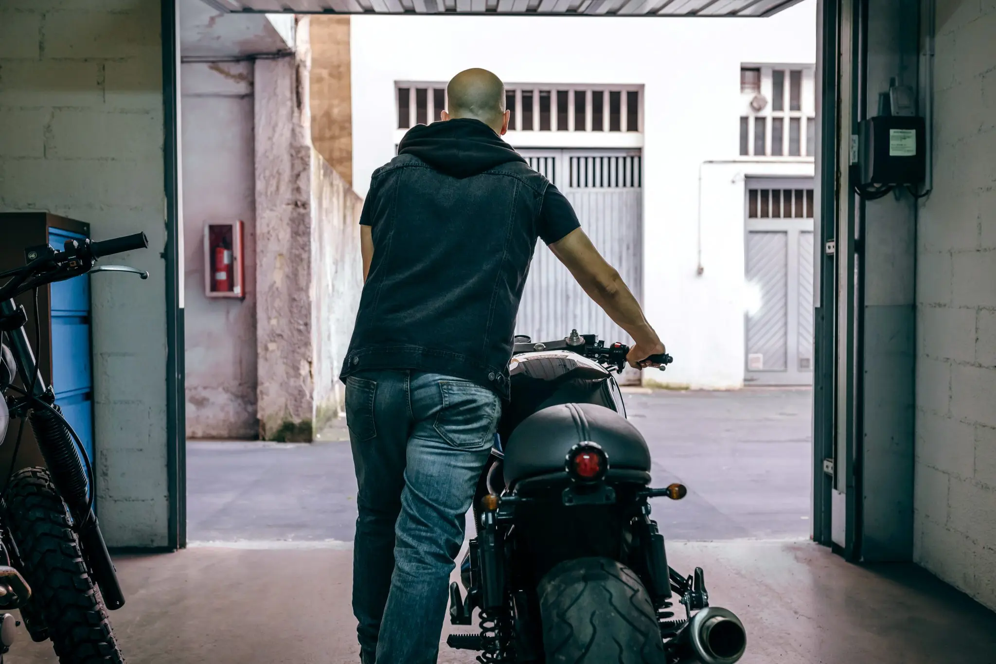 man-with-custom-motorbike-leaving-the-garage